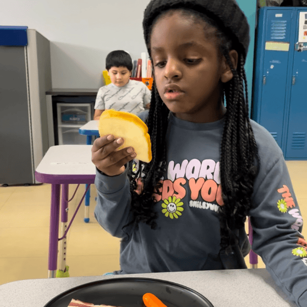 Student looking at piece of toast in classroom