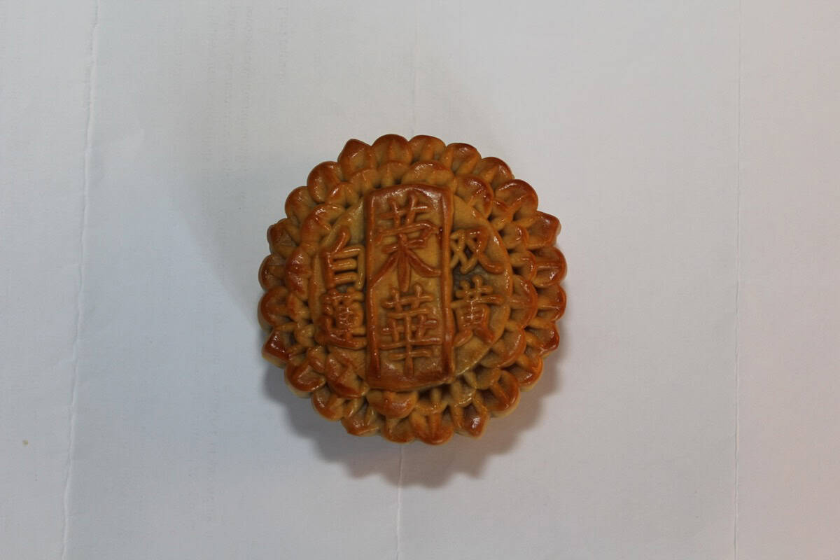 A Wing Wah white lotus seed paste mooncake with two salted egg yolks, stamped 白蓮雙黃 — the Mid-Autumn reunion pastry.