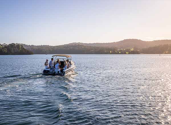 A group on a boat charter to an oyster farm in Narooma