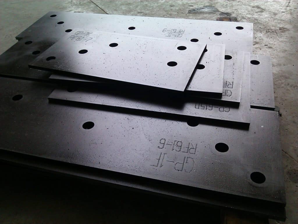 Stack of steel plates with drilled holes for manufacturing processes.