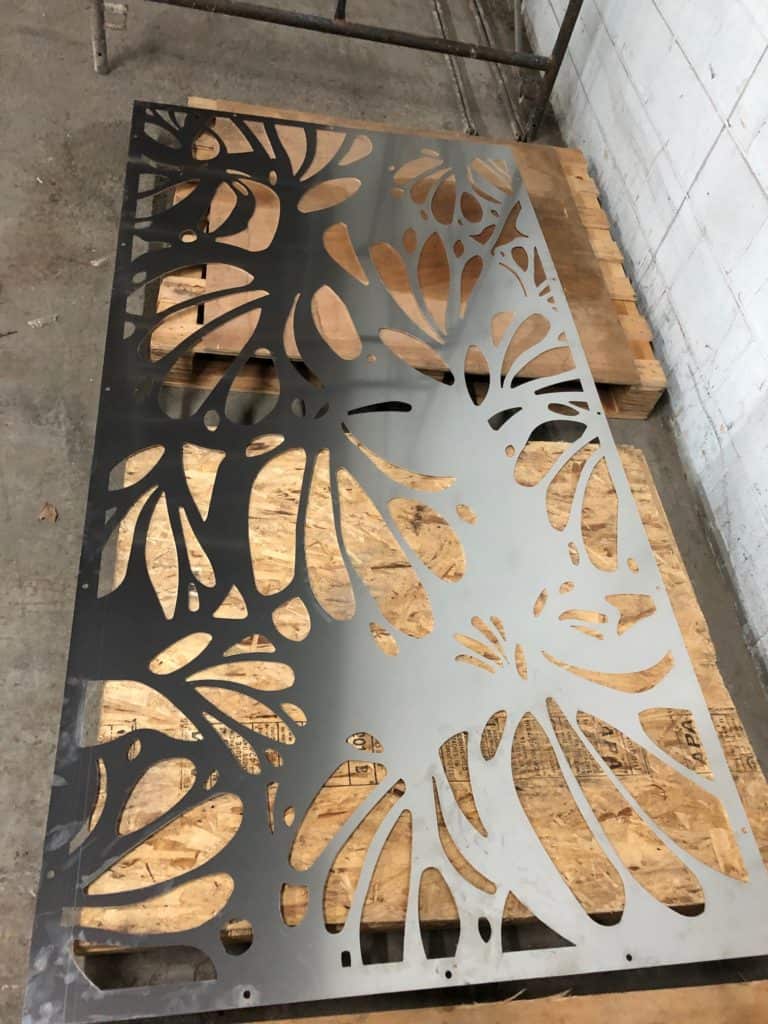 Metal table with intricate leaf cutout design for modern decor.