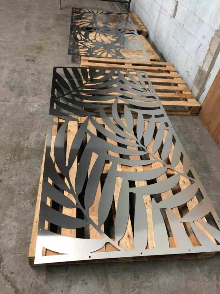 Custom laser-cut metal panels with leaf patterns for architectural design.