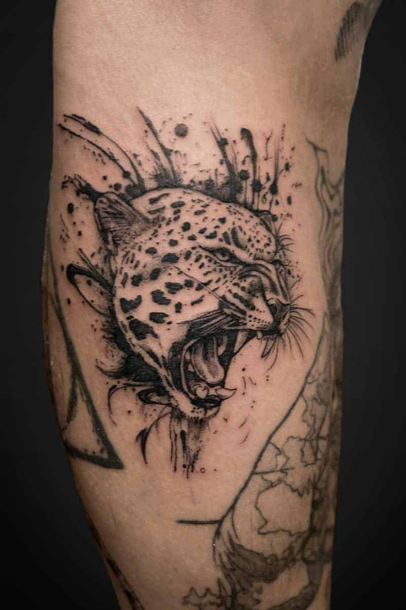 Royal Tattoo| Realism tattoo of of a leopard snarling and abstract ink splashes
