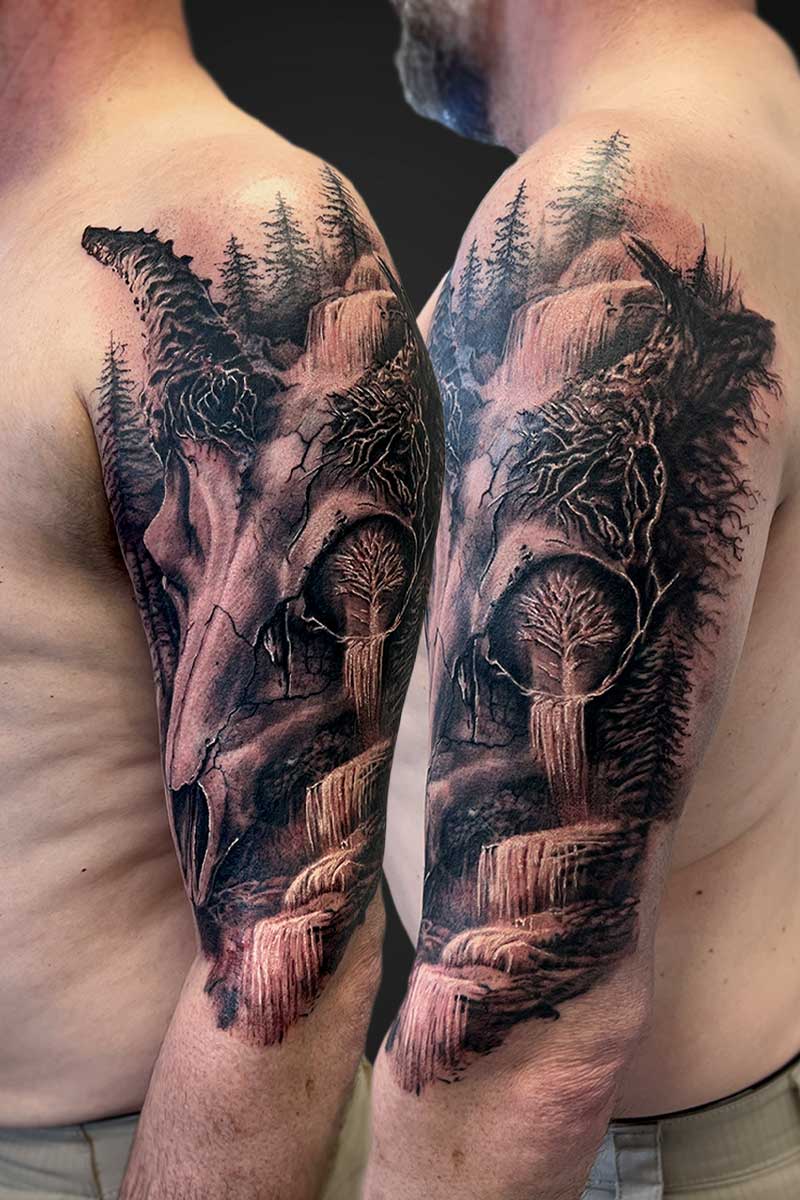 Full-sleeve tattoo of a rugged wilderness scene with waterfalls, rocks, and pine trees across both arms.