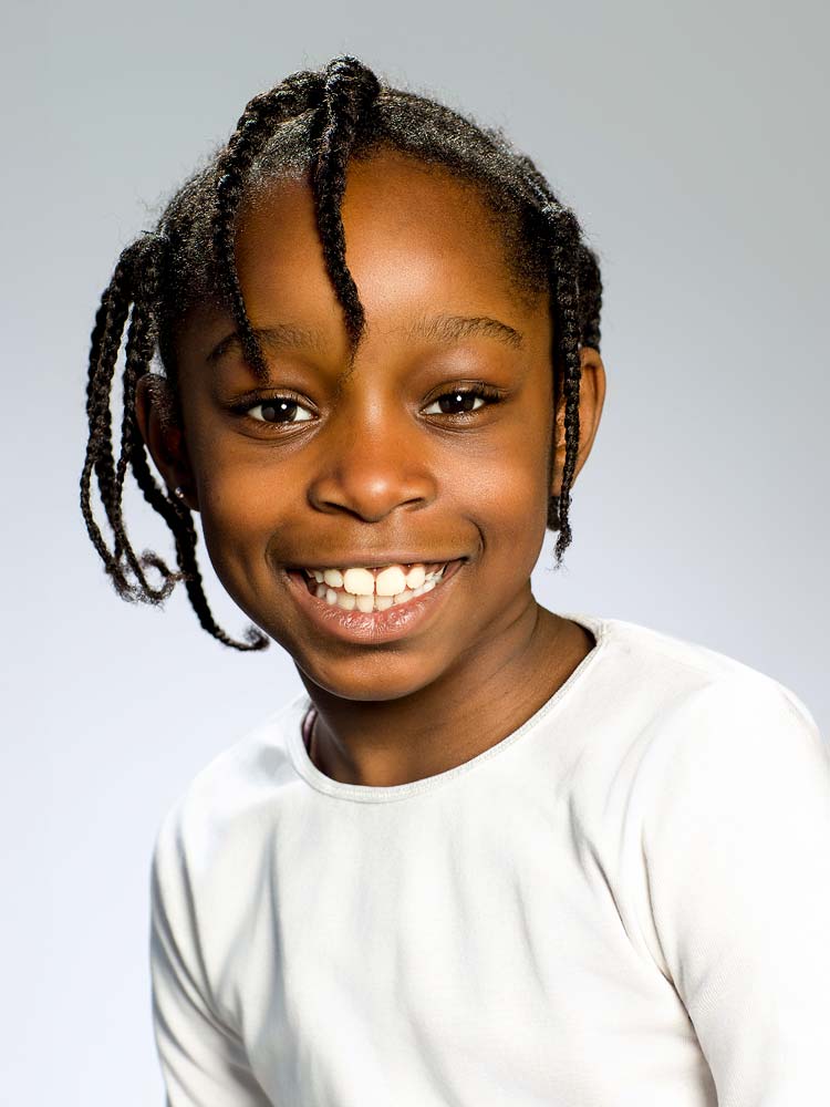 Vibrant headshot of smiling young African girl with natural hair, professional Sussex headshots, perfect for corporate or personal branding images.