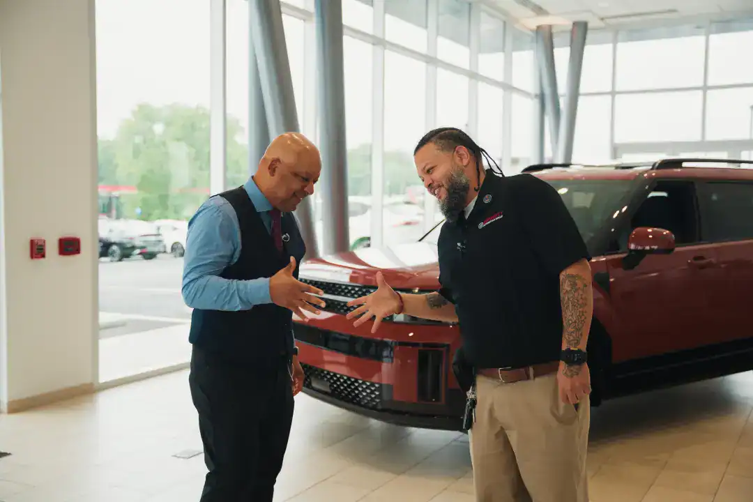 Professional automotive sales consultants discussing vehicle options at Syslo Ventures dealership.