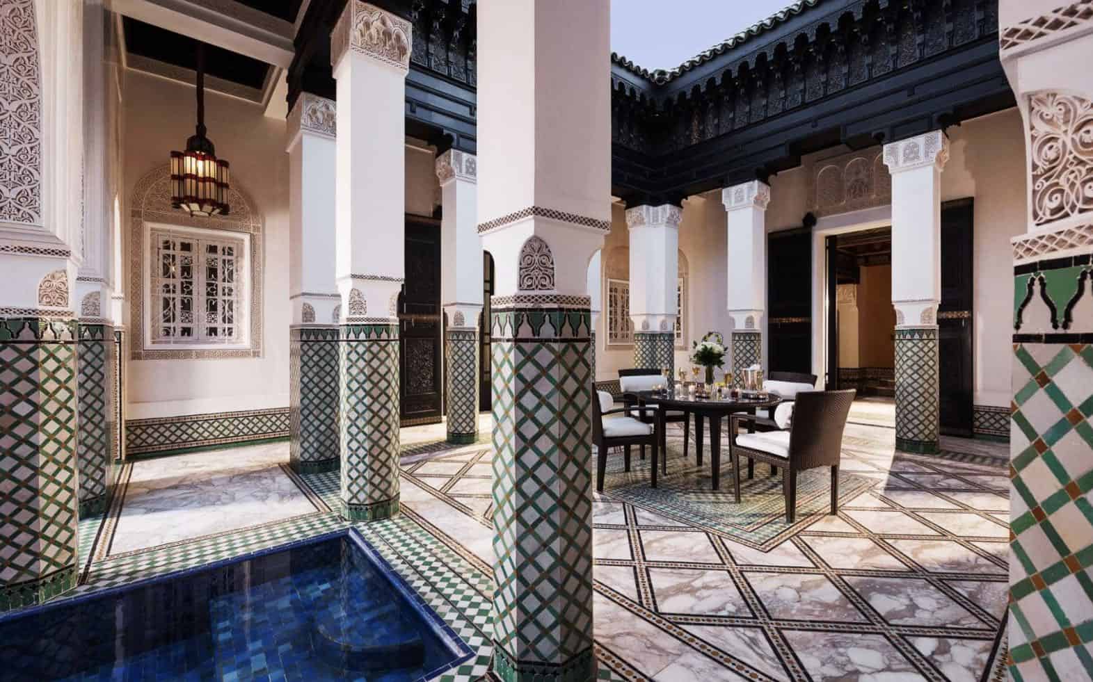 Interior de un hotel de lujo en Marruecos con detalles ornamentales y piscina privada.