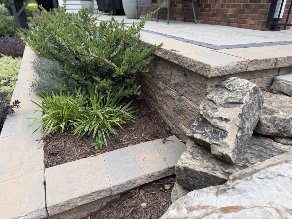 Techo-Bloc Mini-Creta terraced retaining wall installation with planting beds and landscape boulders on the side by TGP Lawn and Landscape in Belmont NC
