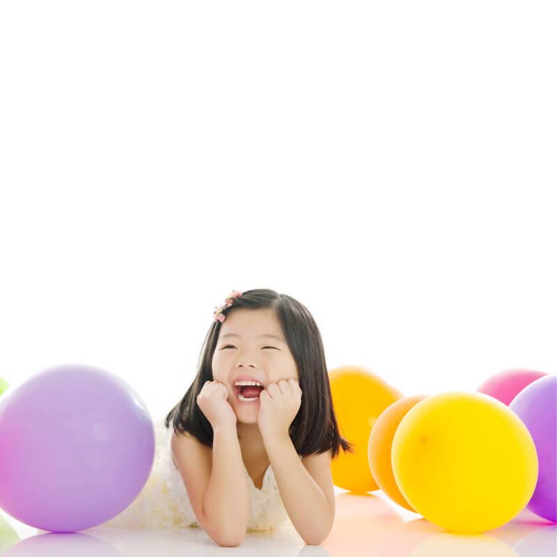 little girl smiling with balloons