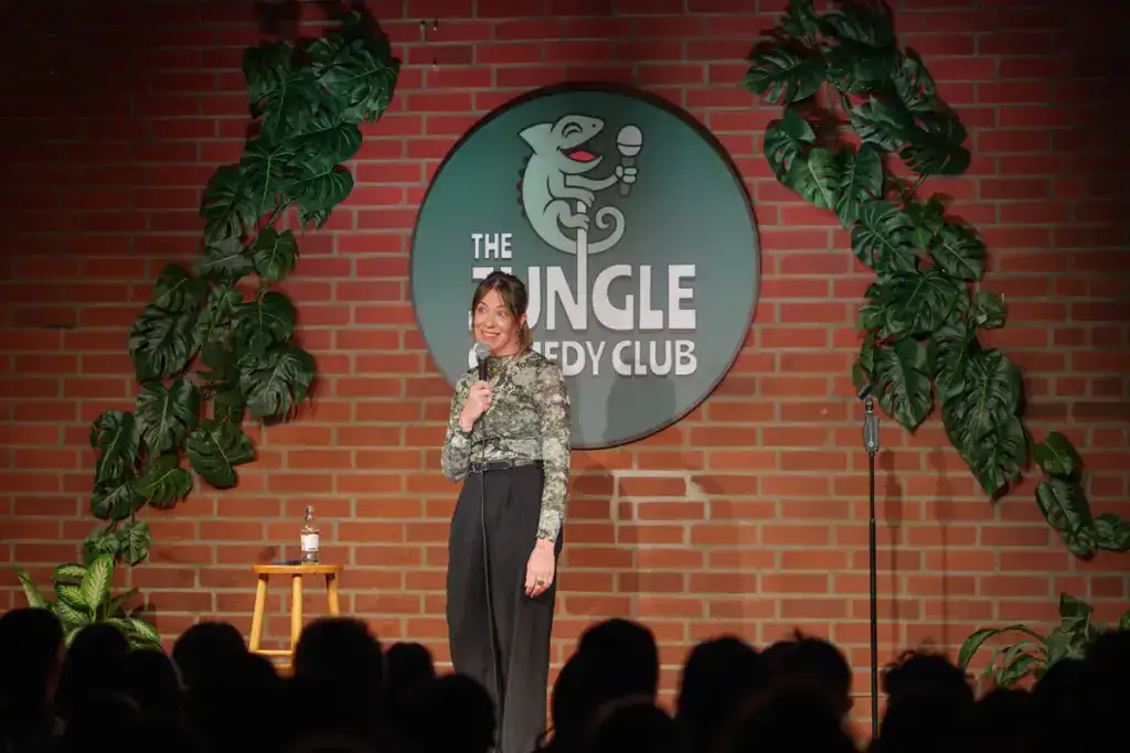 Comedian on the red brick stage at The Jungle Comedy Club