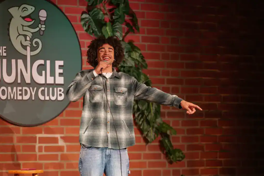 Comedian laughing on stage at The Jungle Comedy Club Munich