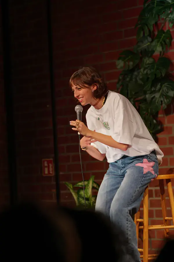 Comedian on a stool at the Jungle Comedy Showcase