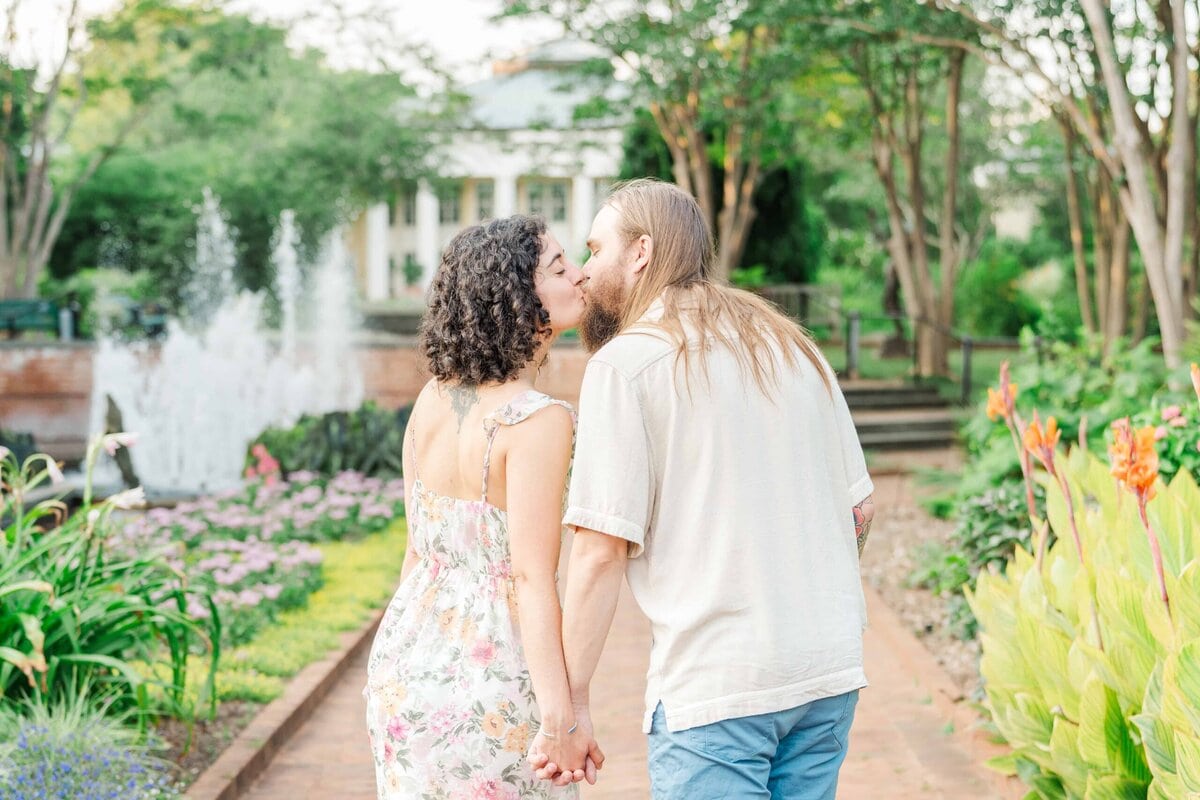 Engaged couple sharing a kiss during photo session at Daniel Stowe Botanical Gardens
