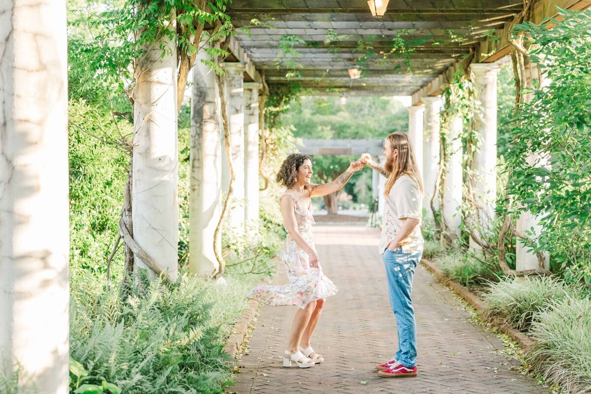 Bride-to-be spinning in garden sunlight during Four Seasons Garden session
