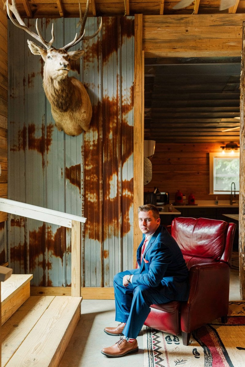 Groom relaxing in the groom’s suite at The Grande Victorian with pool table and comfy couches