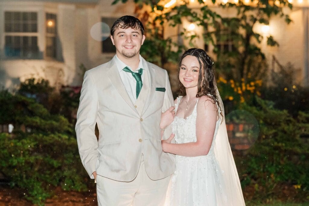 Couple smiling during night portraits at Heron Hill Venue wedding in the rain