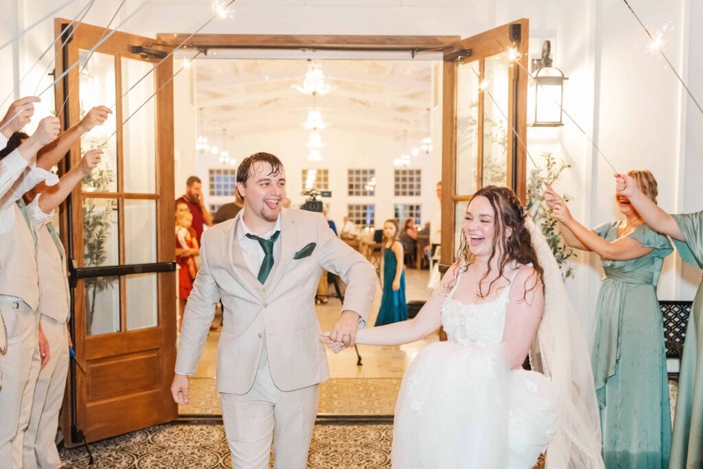 Couple surrounded by sparklers during rainy exit at Heron Hill Venue wedding
