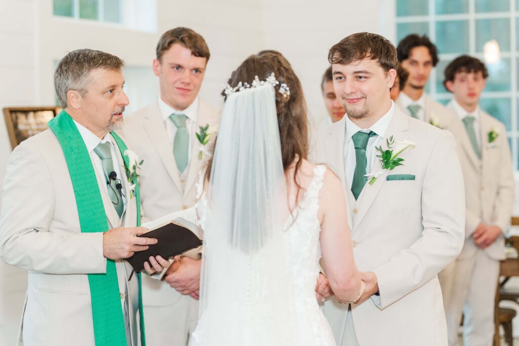 Bride and groom exchanging vows inside reception space at Heron Hill Venue
