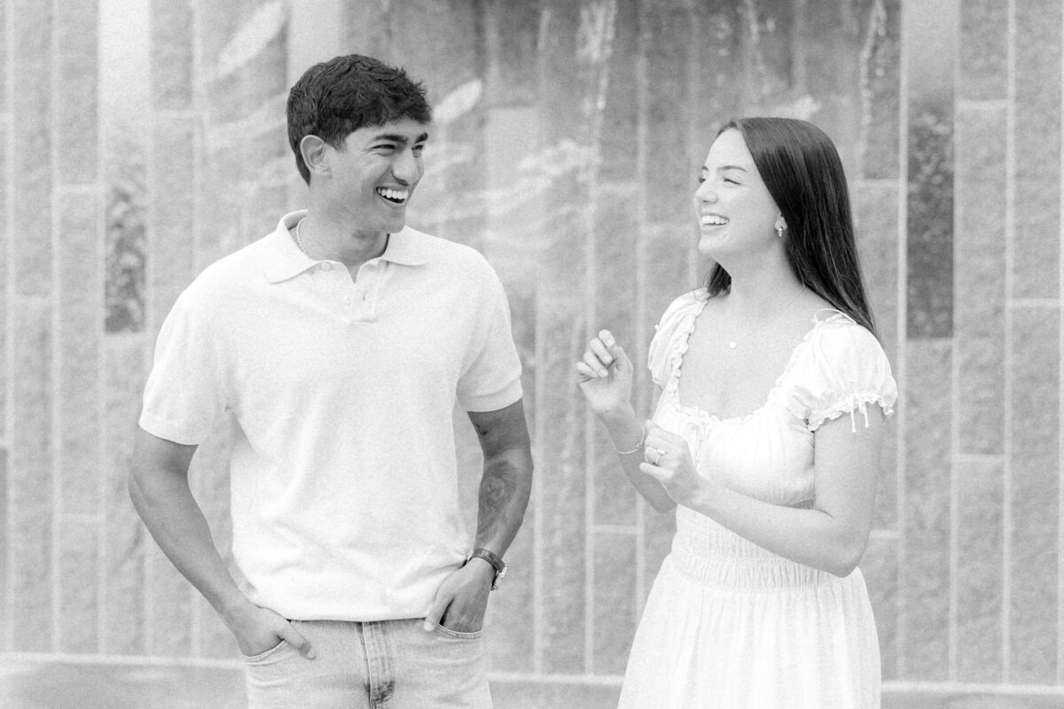 Black and white portrait of engaged couple laughing together