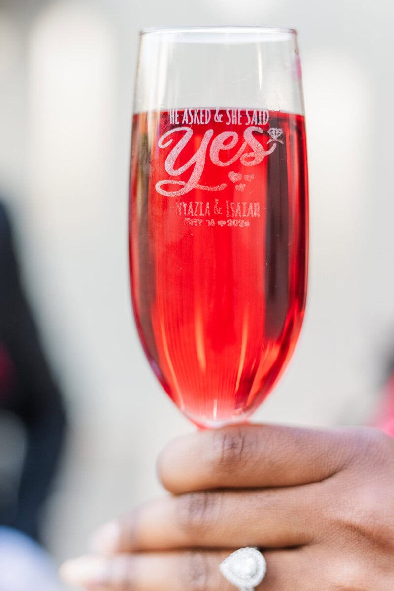 Custom "yes" wine glass with cranberry juice for engagement session toast