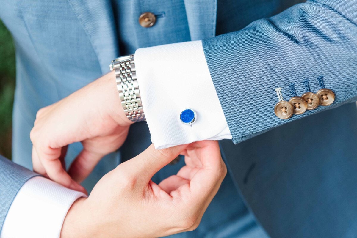 Groom adjusting his blue cufflinks before his Rolling Hill Venue wedding