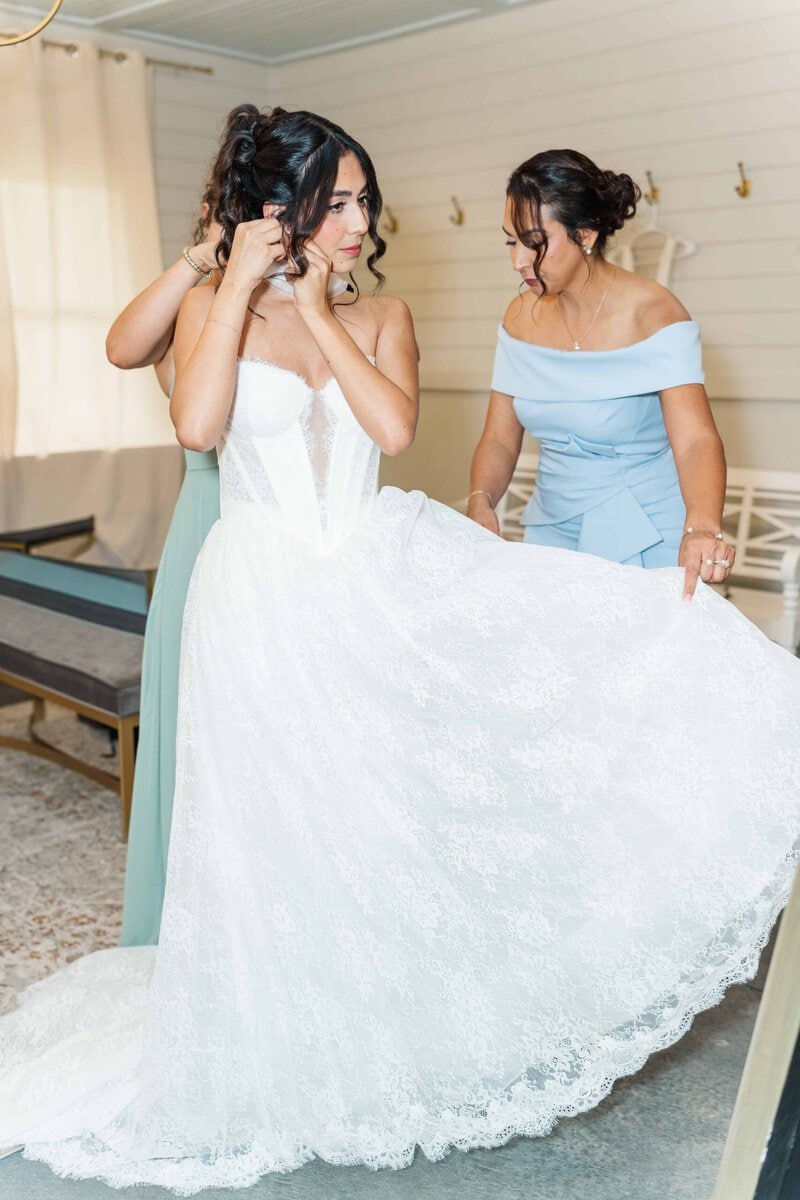 Bride putting in her earrings in the bridal suite at Rolling Hill Venue in Monroe NC