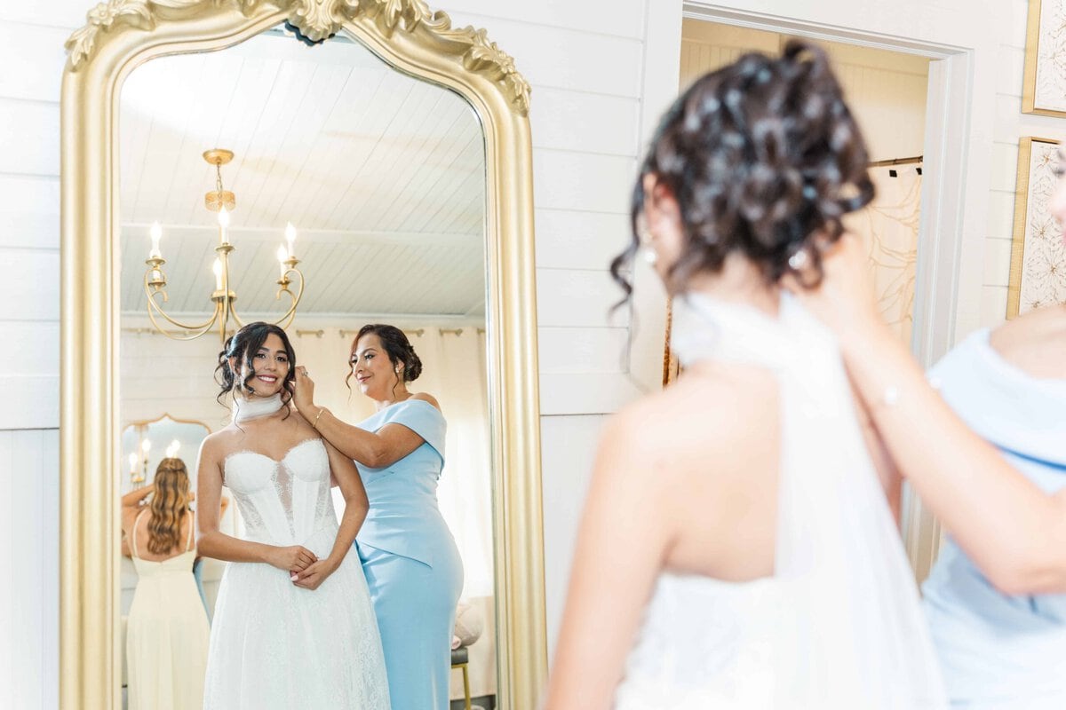 Bride's mother helping her into her lace ballgown before her Monroe NC wedding