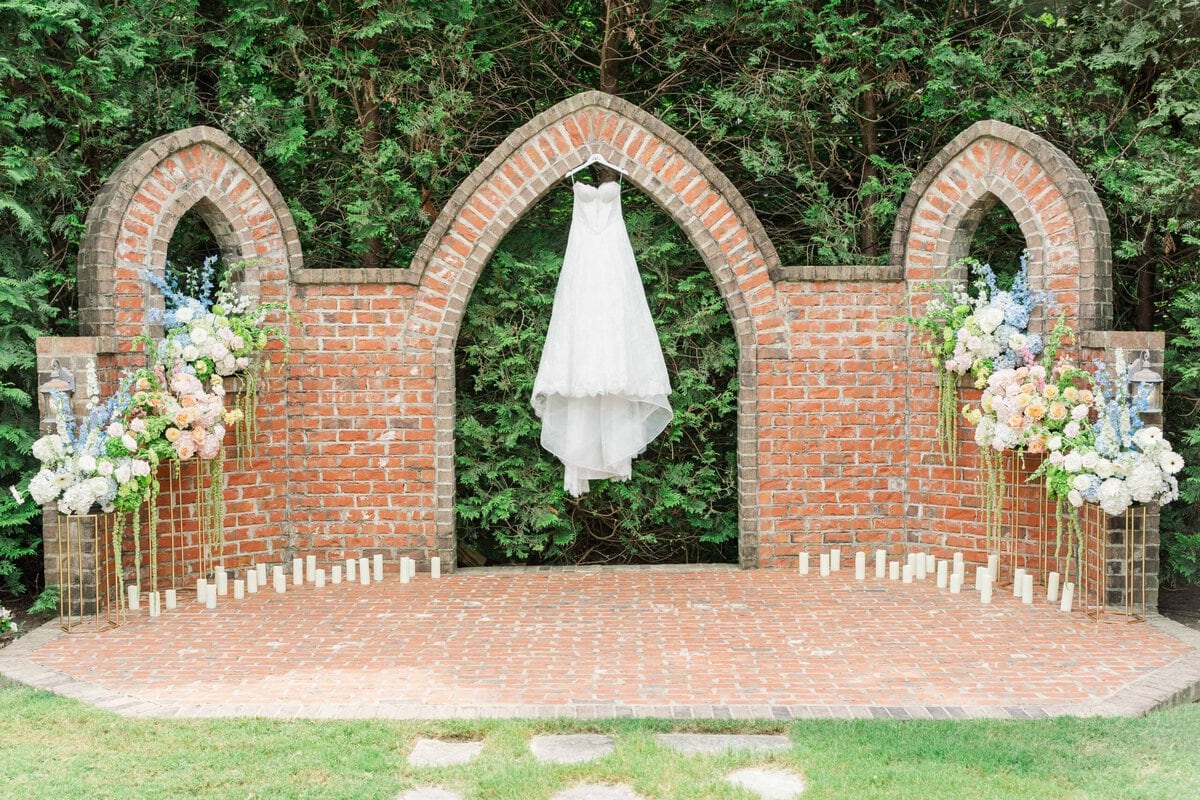 Lace wedding gown hanging on the brick arches at Rolling Hill Venue