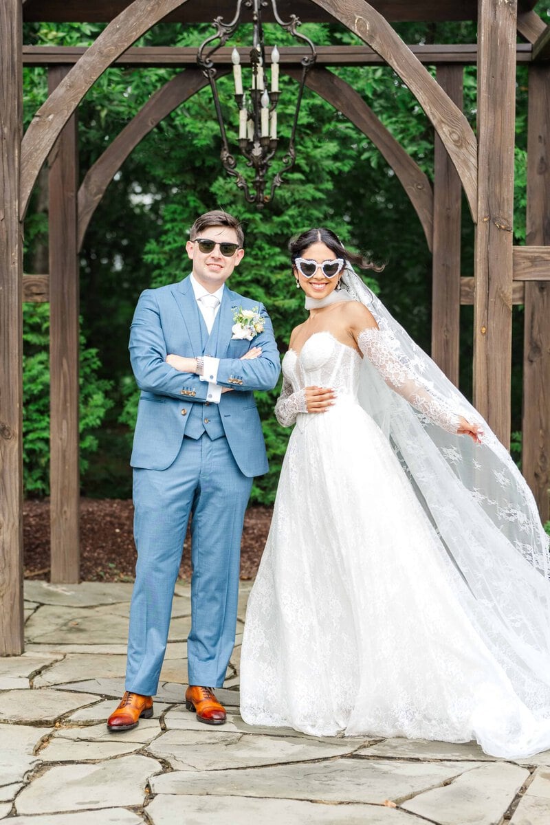 Bride and groom wearing heart shaped sunglasses after their Monroe NC wedding ceremony