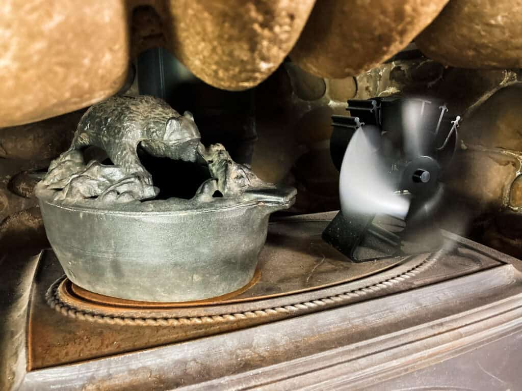 Wood stove accessories. A wood stove humidifier and fan on top of a wood stove.
