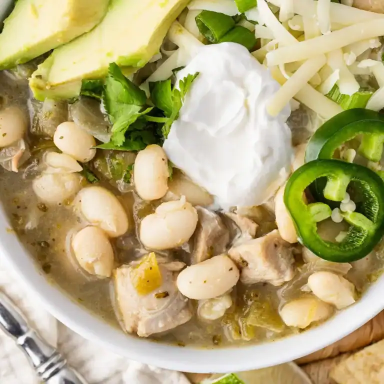 A bowl of white bean and chicken chili garnished with sour cream, avocado, jalapeño and cilantro. Yum!
