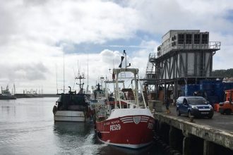Fishing vessels docked at port with industry equipment and gear in a commercial fishing industry.,.