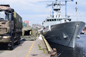 Fishing vessel docked at port with industry equipment and gear visible, commercial fishing context.