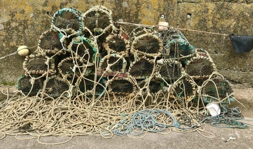 Fishing gear and traps on a fishing vessel deck in a commercial fishing port environment.