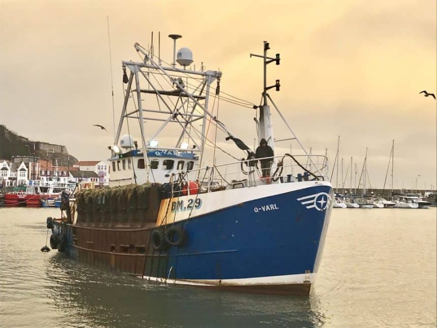 Fishing vessel in port, commercial fishing industry publication, gear and industry equipment visible.