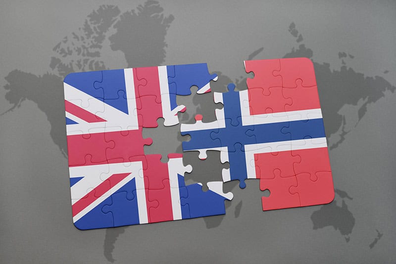 Puzzle pieces with UK and Norway flags on a world map background, symbolizing fisheries cooperation.