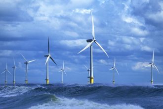 Offshore wind turbines near fishing vessels in the open sea, commercial fishing industry context.