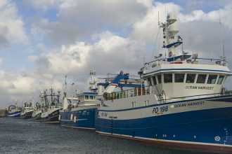 Fishing vessels docked at port, commercial fishing industry publication, gear and industry equipment.
