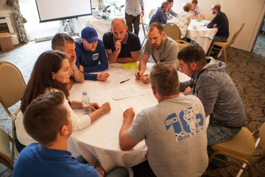 Fishermen and industry professionals discuss at a commercial fishing industry conference table in a.