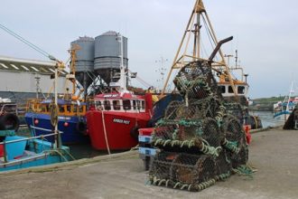 Fishing vessels docked at port with gear and industry equipment in a commercial fishing industry.