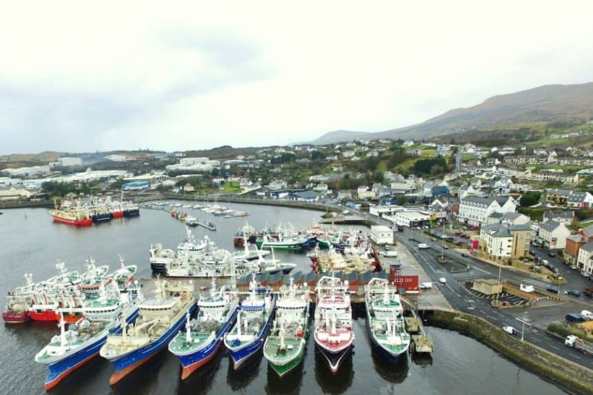 Fishing vessels docked at port in a coastal town, commercial fishing industry scene.