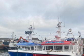 Two fishing vessels docked at port, equipped for commercial fishing operations, industry gear, and m.