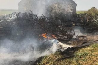 Burned fishing gear and vessels at a port in a commercial fishing industry setting.