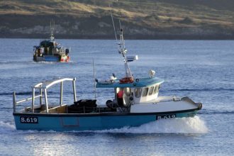 Fishing vessel with gear in port, commercial fishing industry scene, industry equipment, crew, and C.