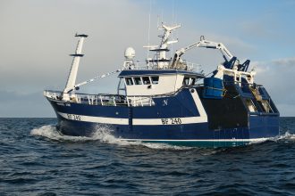 Commercial fishing vessel with gear and industry equipment at sea in a fishing industry publication.