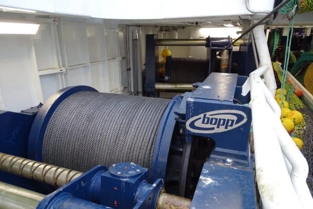 Commercial fishing vessel gear with winch and ropes on a fishing boat in port for industry use.
