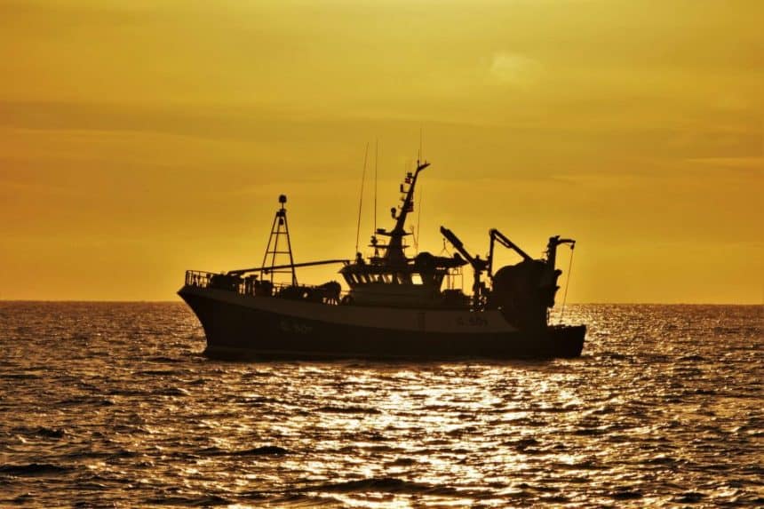 Fishing vessel at sunset in a commercial fishing industry setting.