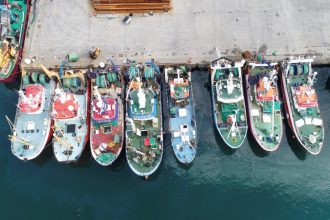 Fishing vessels docked at port in a commercial fishing industry setting.