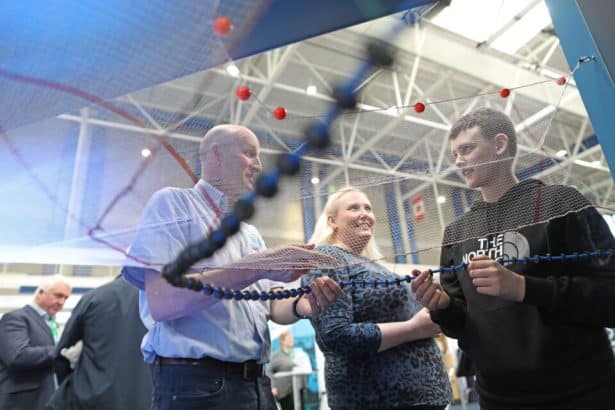 Fishermen exchanging gear at a commercial fishing industry event in an indoor port setting.