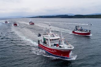 Commercial fishing vessels underway in port, showcasing industry gear and equipment.
